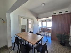 a dining room with a wooden table and chairs at Las Gonzalez in Olavarría