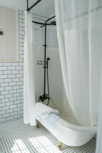 ダロネガにあるDahlonega Inn on Mainの浴室にあるシャワーカーテン付きの白い浴槽