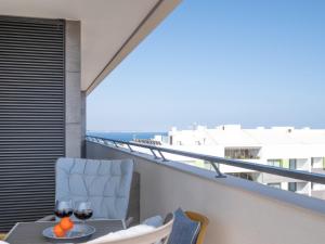 a balcony with a table and two glasses of wine at Sea View Apartment in Santo Amaro