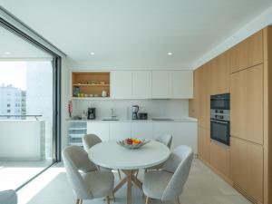 a kitchen with a white table and chairs at Sea View Apartment in Santo Amaro