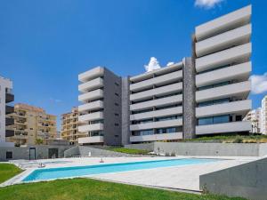 a large building with a swimming pool in front of it at Sea View Apartment in Santo Amaro