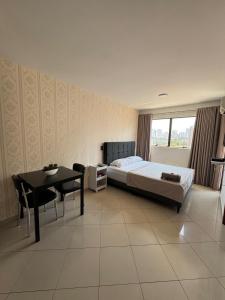 Un dormitorio con una cama y una mesa y una mesa y sillas. en Flat Congonhas sp, en São Paulo