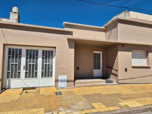 a house with a white door on a street at Las Gonzalez in Olavarría +3 photos