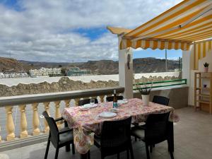 a table on a balcony with a view of the ocean at playa del cura apartment with terrace in Mogán
