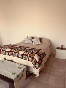 a bed with a comforter and pillows on it at La curva in Ramallo
