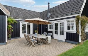 a patio with a table with an umbrella and chairs at Tisvildelund in Vejby +13 photos