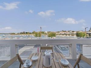 une table sur un balcon avec vue sur un port dans l'établissement Vue rivière - Bel appartement avec balcon pour 8, à Saint-Gilles-Croix-de-Vie