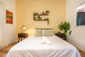 a bedroom with a white bed with plants on the wall at Carmel Emerald in Haifa