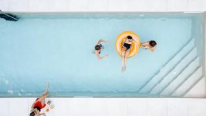 a group of people in a pool with a surfboard at Hotel Indigo Florence by IHG in Florence