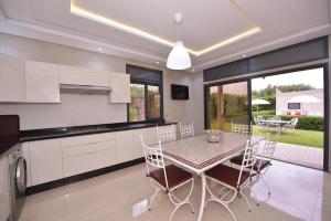 eine Küche und ein Esszimmer mit Tisch und Stühlen in der Unterkunft Villa Route de Fes in Marrakesh in Douar bel Rhanodour