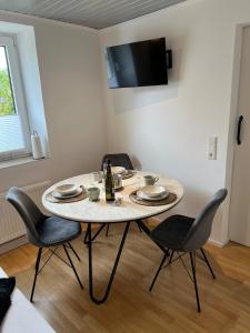 einen Tisch mit Stühlen und eine Flasche Wein darauf in der Unterkunft Little Rose - modern, central with WiFi & parking in Bad Sobernheim