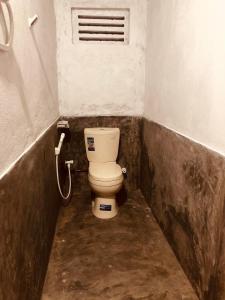 un baño sucio con aseo en un establo en Thalpathwewa Cave Temple, 