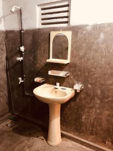 un baño con lavabo y espejo en Thalpathwewa Cave Temple, 