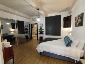 una camera da letto con un letto e una doccia in vetro di Art Deco City Gem in the Heart of Capetown a Città del Capo