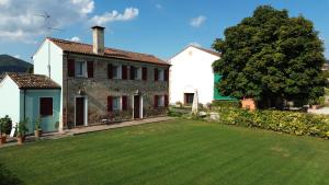 Una casa con un gran césped delante de ella. en Azienda Vitivinicola Ca' Manin, en Vo Euganeo