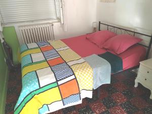 łóżko z kolorową kołdrą w sypialni w obiekcie Appart indépendant, 1 lit deux personnes et 1 appoint Piscine Jardin Direct Gare Aéroport et jardin w Tuluzie +35 zdjęć