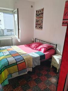 sypialnia z łóżkiem i kolorowym kocem w obiekcie Appart indépendant, 1 lit deux personnes et 1 appoint Piscine Jardin Direct Gare Aéroport et jardin w Tuluzie