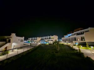 a night view of a row of white buildings at 3 bedrooms villa with own pool! in Pano Dheftera