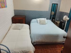 two beds in a small room with at Alojamiento Neres in Salto