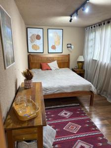 um pequeno quarto com uma cama e uma mesa em Sítio com piscina e churrasqueira em Guapimirim