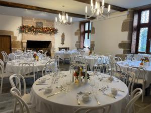 a room filled with tables and chairs with white tablecloths at Manoir de Kerenneur in Plourin