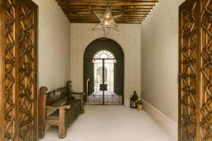 einen Flur mit Holztür und Fenster in der Unterkunft Luxury Condos I Parroquia View & Rooftop Jacuzzi I Paseo del Centro Condominio Boutique in San Miguel de Allende