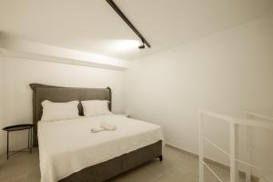 una camera da letto bianca con un letto con una coperta bianca di South Metro Loft ad Atene