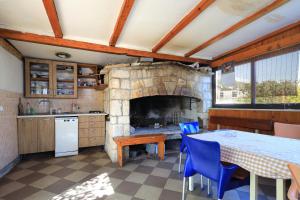 a kitchen with a table and a stone fireplace at Apartments by the sea Seget Vranjica, Trogir - 17989 in Seget Vranjica