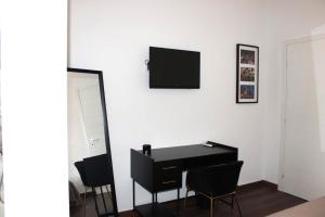 a room with a desk and a television on a wall at Sostal5 in Chiubbica