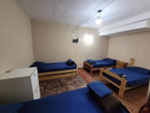 a room with two beds and a table in it at Como en casa Hostel in Posadas