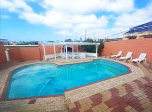 a large swimming pool with two chairs at Sweet Home B & B in East London
