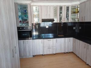 a kitchen with white cabinets and black counter tops at Sweet Home B & B in East London