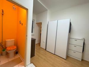 an orange bathroom with a toilet and a refrigerator at Comfy - Old town apartment Bratislava in Staré Mesto +10 photos
