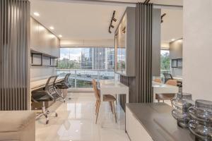 a living room with a table and chairs and a kitchen at 413 Trend Residence High Standard in Porto Alegre