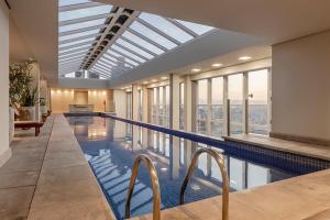an indoor swimming pool with a large glass ceiling at 413 Trend Residence High Standard in Porto Alegre