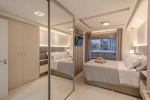 a bedroom with two beds and a mirror at 413 Trend Residence High Standard in Porto Alegre +13 photos