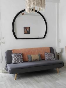 Un sofá en una sala de estar con un espejo. en Gite Iza, en Lormes