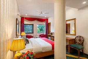 a bedroom with a bed and a desk and a window at Hotel Kwality Regency in Chandīgarh +5 photos