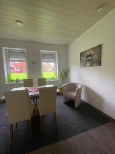 a dining room with a table and chairs and two windows at Auf dem Land 