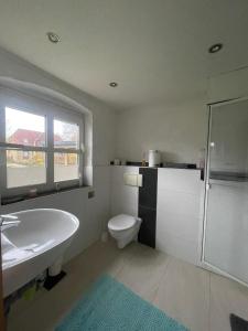 a white bathroom with a sink and a toilet at Auf dem Land in Wittbek +11 photos