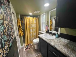 une salle de bain avec un lavabo et des toilettes, et un rideau de douche jaune dans l'établissement 3 Homes on Blueberry Farm - Waterfall, Game Room, à Mentone 63 autres photos