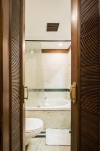 a bathroom with a toilet and a bath tub at Hotel Kwality Regency in Chandīgarh