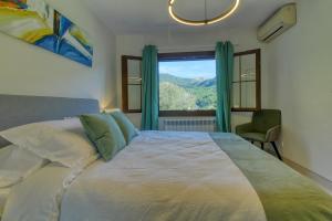 a bedroom with a large bed with a large window at Best Views in Valldemossa in Valldemossa