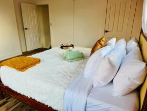 a large bed with white sheets and pillows at Jungle House Luxury Homes - Columbus Downtown Short North - Steps to Convention Center & Nationwide Arena - Sleeps up to 8 - Free Parking - Over 5,800 Five Stars in Columbus