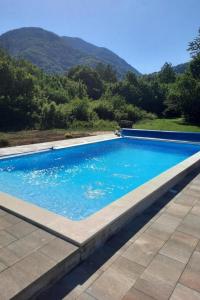 a swimming pool with blue water and mountains in the background at Family friendly house with a swimming pool Gospic, Velebit - 21171 in Gospić