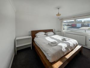 a bedroom with a bed with two towels on it at Springfield Bungalow in Cliftonville