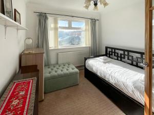 a bedroom with a bed and a chair and a window at Springfield Bungalow in Cliftonville +8 photos