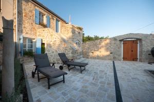 a patio with chairs and a table and a building at Holiday house with a parking space Vir - 23510 in Vir +15 photos