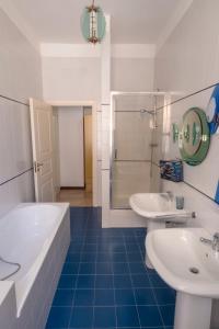 een badkamer met twee wastafels, een bad en een douche bij San Lorenzo by the sea in Augusta