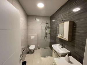 a bathroom with a toilet and a sink at PrishtinaRoyalty in Pristina